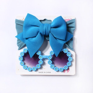 Blue bow headband and daisy sunglasses set for infants on a display card