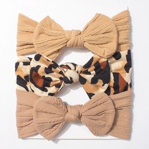 Détail de trois bandeaux bébé avec textures tricotées et motif léopard sur carte