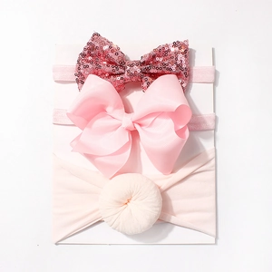 Detailed view of 3-piece pink baby headband set featuring sequins and ribbed bow textures