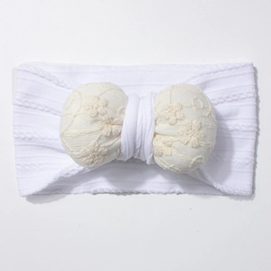 Detail of soft jacquard elastic baby headband with white lace crochet flower bow