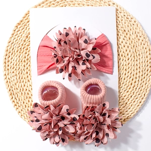 Detail view of salmon pink baby headband and socks set with 3D floral heart patterns