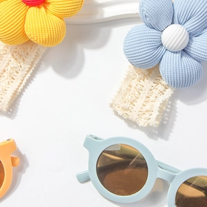 Details von Baby-Spitzenstirnbändern mit Strickblumen und runder Sonnenbrille in Pastell