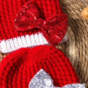 Close-up of knit baby hats featuring sparkling sequin bows and textured knit fabric