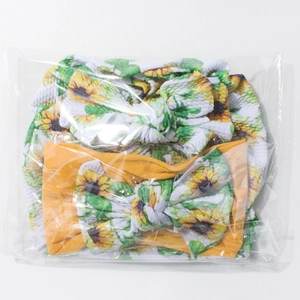 Détail de deux bandeaux pour bébé avec motifs de tournesols et grands nœuds en tissu doux