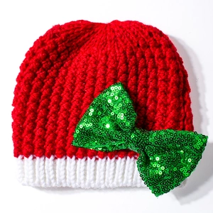 Red Christmas knit baby hat with white trim and a festive green sequin bow decoration
