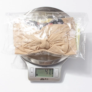 Detail of baby headband set on a kitchen scale showing a light weight of 41.1g