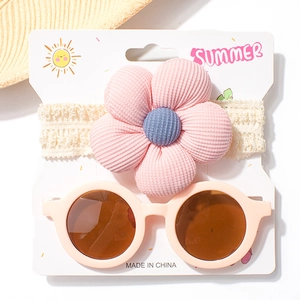 Baby-Set mit rosa Spitzenblumen-Stirnband und runder Sonnenbrille auf Displaykarte