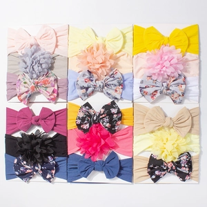 Set of 12 colorful baby nylon headbands with large bows and floral designs on white cards