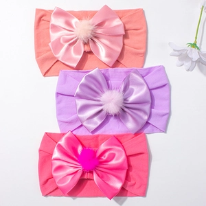 Lot de trois bandeaux bébé en nylon avec nœuds en satin et pompons de couleurs douces