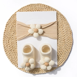 Detailed set of knit baby headband and matching socks with 3D daisy flower decorations