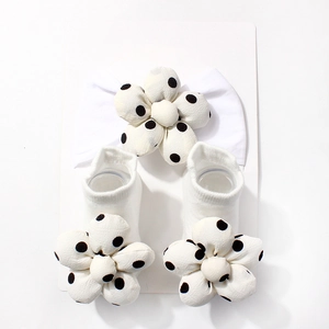 Detailansicht von Baby Haarband und Socken Set mit schwarz-weißen Polka-Dot-Blumen