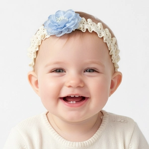 Gros plan d'un bébé portant un bandeau en dentelle élastique avec fleur en maille bleue