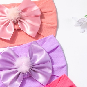 Gros plan de bandeaux bébé en nylon avec nœuds en satin doux et pompons en peluche