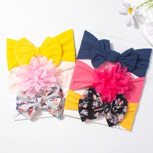 3-piece set of baby headbands with colorful large bows and floral patterns on card