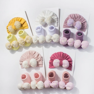 Détail de bonnets turban et chaussettes bébé avec nœuds en dentelle en cinq couleurs