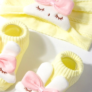 Detail of yellow ribbed baby socks and nylon headband with cute plush bunny decorations