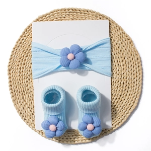 Detail showing baby headband and socks set with 3D floral accents in light blue