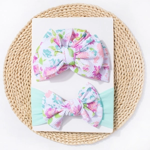 Détail d'un turban pour bébé en tricot gaufré à fleurs et d'un bandeau à nœud