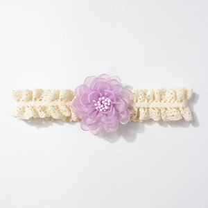Détail d'un bandeau en dentelle pour bébé avec fleur en organza violette et pistils