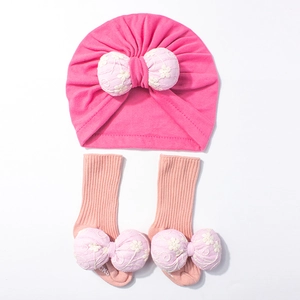 Détail du bonnet turban et des chaussettes rose pour bébé avec broderie florale
