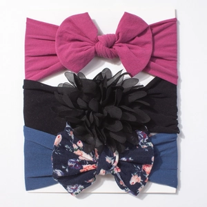 Three-piece baby headband set with bright pink bow, black flower, and floral patterns