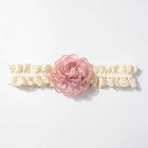 Détail du bandeau en dentelle pour bébé avec fleur en mousseline rose et ruban doux