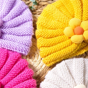 Dettagli della trama a maglia e decori floreali su cappelli invernali per neonati