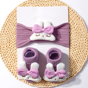 Detailed close-up of purple baby headbands and socks set with plush bunny decorations