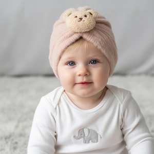 Close-up of pink plush baby beanie with cute 3D teddy bear ears for winter warmth