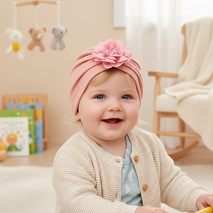 Dettaglio di una neonata che indossa un turbante rosa con un grande fiore in tessuto 3D