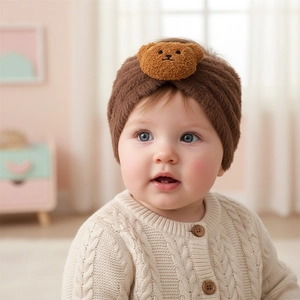 Close-up of baby winter plush headband with cute 3D teddy bear doll and soft knit texture