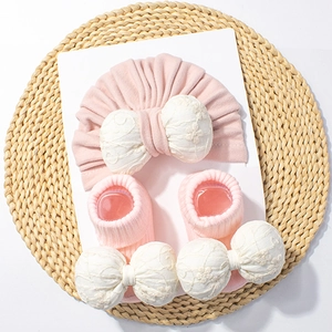Détails d'ensemble bonnet et chaussettes bébé rose avec nœuds en dentelle florale