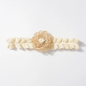 Détail de la fleur en tissu champagne et du bandeau en dentelle élégant pour bébés