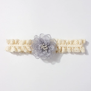 Détail du bandeau en dentelle pour bébé avec fleur en mousseline grise et étamines blanches