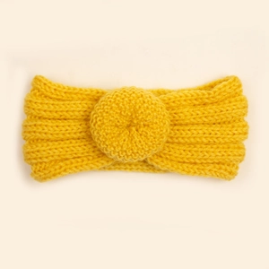 Détail d'un bandeau en tricot jaune pour bébé montrant la texture épaisse et le nœud