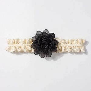 Détail du bandeau en dentelle pour bébé avec fleur en tissu noir 3D et perles décoratives