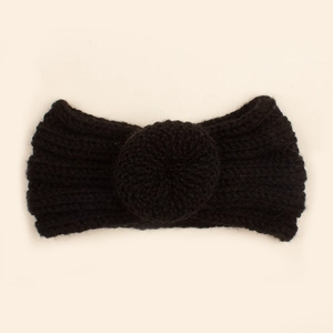 Détail d'un bandeau en maille noire pour bébé avec un grand nœud décoratif en relief