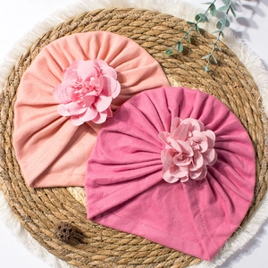 Vista dettagliata del turbante neonato in maglia morbida con fiori in tessuto 3D multistrato