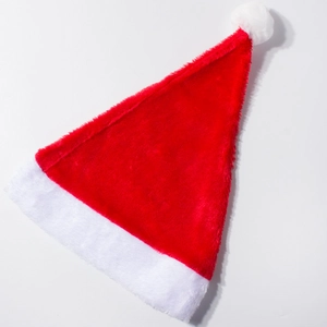Gros plan sur la texture douce en peluche et le pompon blanc du bonnet de Noël rouge