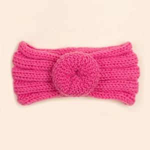 Texture de tricot détaillée et nœud beignet du bandeau d'hiver rose chaud pour bébé