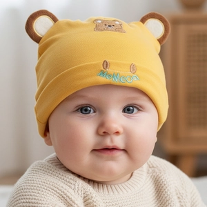 Close-up of yellow baby bear hat with cute bear ears and soft knitted cotton texture