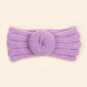 Gros plan d'un bandeau bébé en maille violette avec boule de beignet tricotée décorative