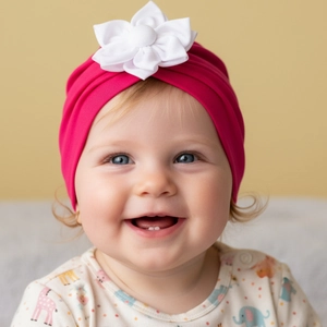 Close-up of baby girl wearing a rose red floral knit hat with a large white flower