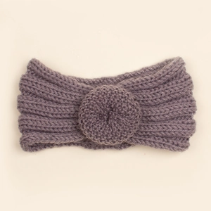 Gros plan d'un bandeau en tricot violet foncé pour bébé avec une fleur au crochet