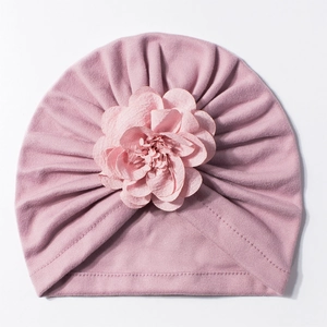 Dettaglio del cappellino neonato con pieghe in maglia e un ornamento floreale 3D stratificato