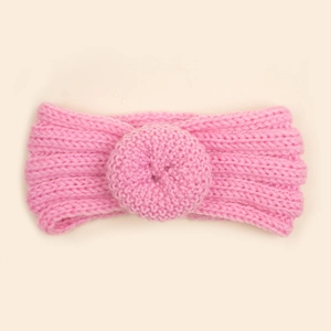 Détail du bandeau tricoté rose pour bébé montrant la texture de maille et le décor de donut