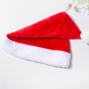 Gros plan du tissu en peluche rouge doux et du pompon blanc sur le bonnet de Noël classique