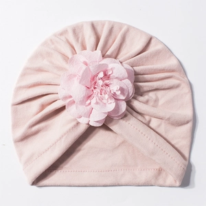 Vista dettagliata del cappello a turbante rosa per neonati con grande fiore in tessuto