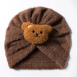 Detailed close-up of dark brown plush baby turban hat with a cute 3D bear face