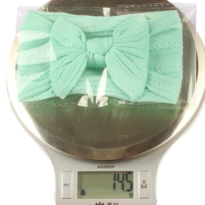 Vue détaillée sur balance montrant le poids du bandeau bébé en nylon vert menthe à 14,5g